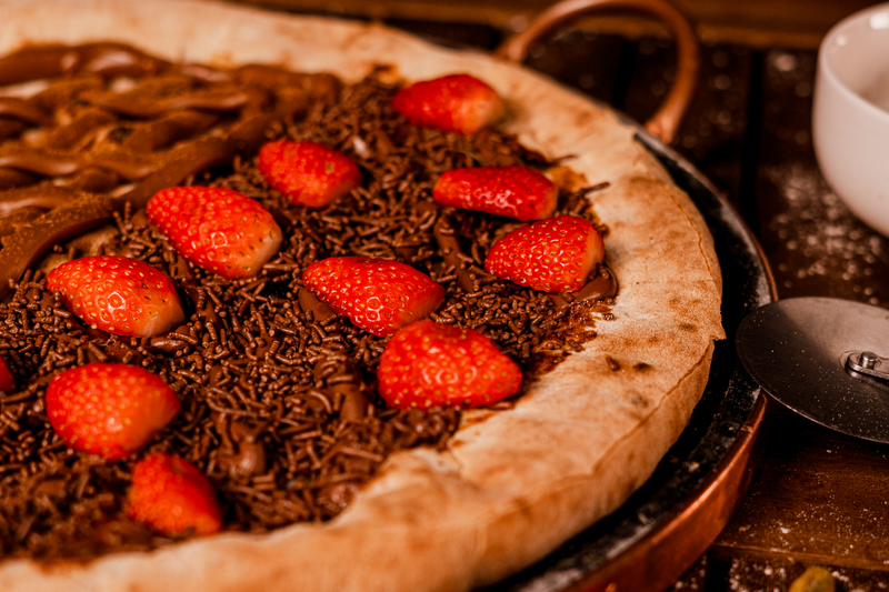Nutella pizza dessert with berries and powdered sugar